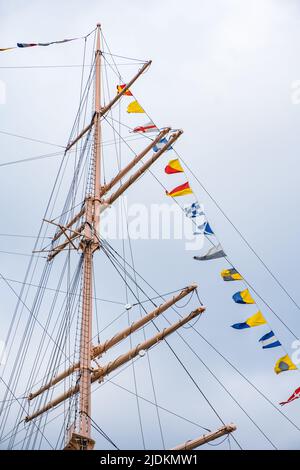 Spedire il montante con bandierine colorate contro il cielo Foto Stock