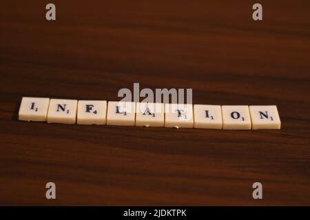 Primo piano mirato selettivo della parola inflazione . Fatto usando le lettere in blocchi in uno sfondo di legno. Foto Stock