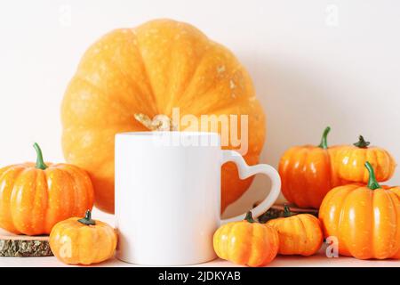 Tazza di caffè bianca e molti pomprini caduta mockup. Foto Stock