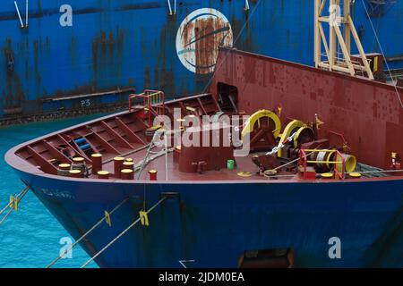 Lato anteriore della nave da trasporto sull'acqua, vista dall'alto. La prua della nave con un verricello di ancoraggio, corde sul ponte, bullarde di ormeggio e pneumatici auto sul Foto Stock