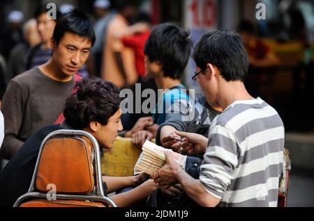 CINA, Guangzhou, lo scambio di denaro illegale di Yuan cinese e dollari USA per strada / CINA , Provinz Guangdong, Metropole Guangzhou, Kanton, Schwarzmarkt für Geldwechsel, Umtausch von Devisen wie Dollar in Yuan Foto Stock