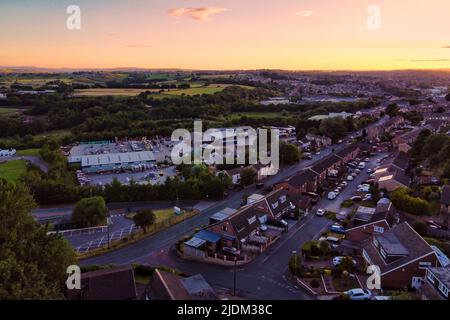 Drone urbano immagine di alloggi tipici del Regno Unito. Tramonto con case in mattoni rossi e zona industriale Foto Stock