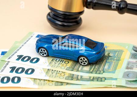 Gavel di giudice, modello di auto e 100 banconote in euro sul tavolo in tribunale, quadro concettuale Foto Stock