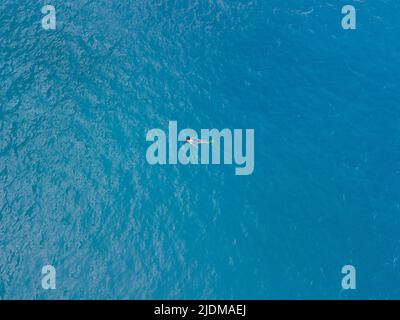 vista dall'alto della donna che nuota in pinne d'acqua di mare blu Foto Stock