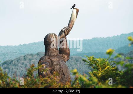 Soldato gigante che tiene il corno monumento statua a Didgori - sito storico memoriale. Luoghi di interesse storico della Georgia Foto Stock