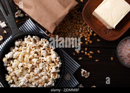 Popcorn in padella in ghisa con burro a parte piatto Foto Stock