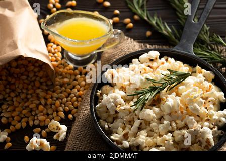 Popcorn in padella di ghisa con burro fuso a parte Foto Stock