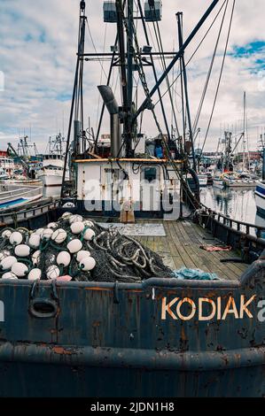 Una barca da pesca invecchiata con reti si trova in una marina sull'isola di Kodiak, Alaska, Stati Uniti Foto Stock