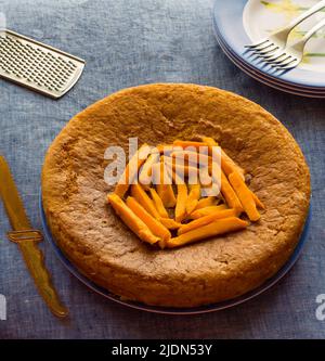 Vista sulla testa della torta Mango su sfondo blu chiaro. Fatta in casa, umido, torta di frutta fresca per natale, estate, primavera. Condito con fettine di mango. Foto Stock