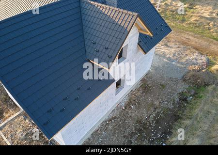 Vista aerea di casa incompiuta con pareti in calcestruzzo leggero aerato e telaio del tetto in legno rivestito con piastrelle metalliche in costruzione Foto Stock