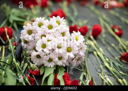 Fiori sul memoriale. Bouquet di fiori su lapide. Dettagli della cerimonia funebre. Foto Stock