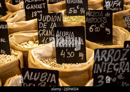 Sacchi di stoffa contenenti grani destinati alla vendita sul mercato. Cibo con i loro nomi e prezzi in euro. Messa a fuoco selettiva. Foto Stock