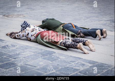 Pellegrini stesi sul pavimento dopo essersi prostrati. Facendo il 'Barkhor Kora', un circuito devozionale pellegrino intorno all'esterno della vecchia Jokhang T. Foto Stock