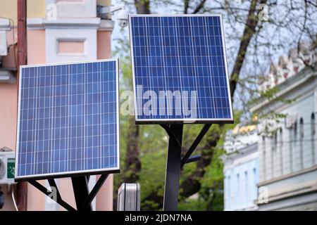 Pannelli solari fotovoltaici montati su palo urbano per la fornitura di energia elettrica di lampioni e telecamere di sorveglianza Foto Stock