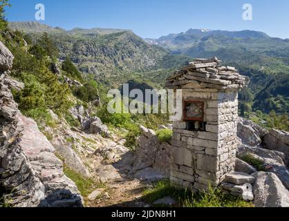 Sentiero ripido sopra il villaggio di Tsepelovo nella regione Zagori della Grecia settentrionale con il monte Timfi e la vetta Gamila in lontananza Foto Stock