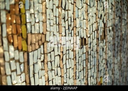 Piastrelle sul muro. Lo sfondo è rotto. Mosaico di pietra. Foto Stock