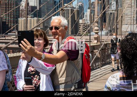 Coppia anziana che prende selfie sul Brooklyn Bridge Pedestrian Walkway a New York City, Stati Uniti d'America Foto Stock