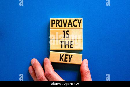 Privacy è il simbolo chiave. Concetto parole Privacy è la chiave su blocchi di legno su una bella tabella blu sfondo blu. Mano dell'uomo d'affari. Business, fi Foto Stock