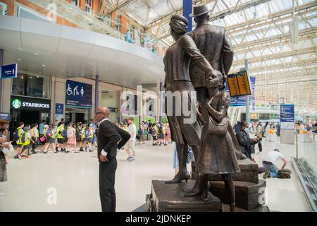 22nd giugno 2022. Londra, Regno Unito. Il National Windrush Monument nella stazione di Waterloo. Il personale ferroviario posa di fronte allo scultore giamaicano Basil Watson, raffigurante una famiglia caraibica che sormonta un mucchio di valigie, è il National Windrush Monument che commemora il contributo degli immigrati dai Caraibi che hanno contribuito a ricostruire la Gran Bretagna dopo la guerra mondiale del 2. Credit peter Hogan/ALAMY Foto Stock