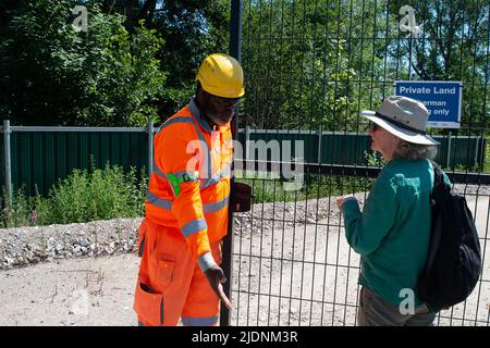 Harefield, Uxbridge, Regno Unito. 22nd giugno 2022. Una Guardia di sicurezza del HS2 chiude il cancello sulla baronessa Jenny Jones di Moulsecoomb mentre si trova al di fuori del composto del HS2. Nonostante l'età media del partito sia ben oltre 60 anni e il fatto che si trovavano in piedi su un terreno pubblico al di fuori della scherma del HS2, HS2 Security ha richiesto il backup. Credit: Maureen McLean/Alamy Live News Foto Stock