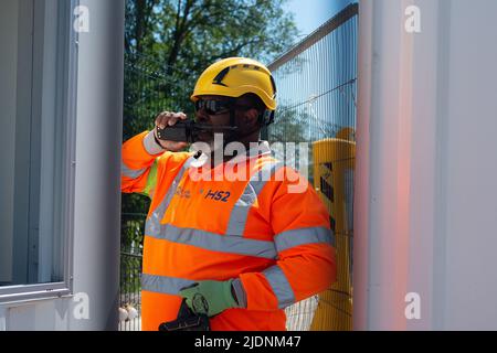 Harefield, Uxbridge, Regno Unito. 22nd giugno 2022. Una Guardia di sicurezza del HS2 chiude il cancello sulla baronessa Jenny Jones di Moulsecoomb mentre si trova al di fuori del composto del HS2. Nonostante l'età media del partito sia ben oltre 60 anni e il fatto che si trovavano in piedi su un terreno pubblico al di fuori della scherma del HS2, HS2 Security ha richiesto il backup. Credit: Maureen McLean/Alamy Live News Foto Stock