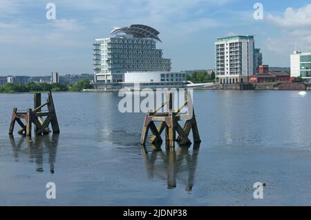 Vista del St David's Hotel (Voco) attraverso la baia di Cardiff con vecchi ormeggi in legno - chiamati delfini. 2022 Foto Stock