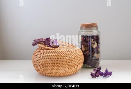 scatola di rattan in vimini con top rotondo con fiori secchi e lavanda su sfondo bianco Foto Stock