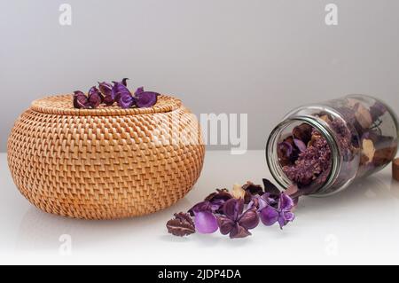 scatola di rattan in vimini con top rotondo con fiori secchi e lavanda su sfondo bianco Foto Stock