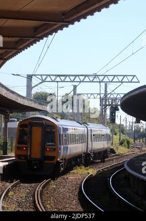 I treni Nord classe 158 Express Sprinter dmu, numero 158844, lasciando la piattaforma 1 alla stazione ferroviaria di Carnforth mercoledì 22nd giugno 2022. Foto Stock