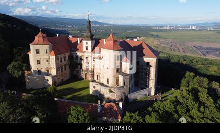 Castello di Jezeri situato vicino alla miniera di carbone nella Boemia settentrionale, castello di Stato di Jezeři, Repubblica Ceca. Panorama panoramico con brutale cava di carbone Foto Stock