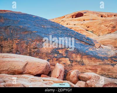 Formazioni di roccia rossa con incisioni rupestri di roccia di antiche culture degli Indiani d'America nel deserto di Mojave, nel parco statale della Valle del fuoco, Nevada Foto Stock