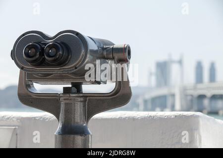 Telescopio binoculare per turisti montato nella città moderna, foto ravvicinata con fuoco selettivo Foto Stock