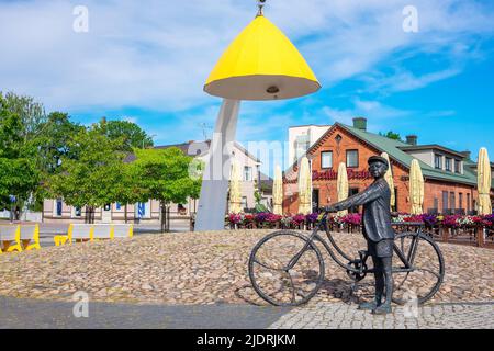 Piazza centrale con scultura "giovane uomo in bicicletta che ascolta musica". Rakvere, Estonia Foto Stock