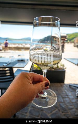 Bere txakoli o Chacolí vino bianco leggermente frizzante molto secco prodotto nei Paesi Baschi spagnoli, servito nel ristorante di Getaria pescatore Foto Stock