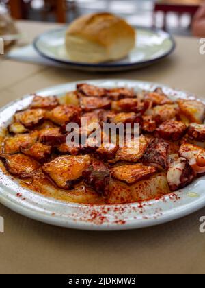 Gustosi frutti di mare, polpo alla griglia in stile galiziano con paprika pimento rosso e patate serviti nel ristorante spagnolo Foto Stock