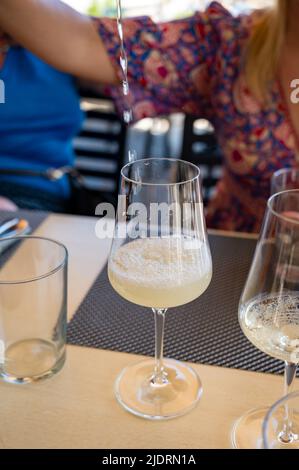 Bere txakoli o Chacolí vino bianco leggermente frizzante molto secco prodotto nei Paesi Baschi spagnoli, servito nel ristorante di Getaria pescatore Foto Stock