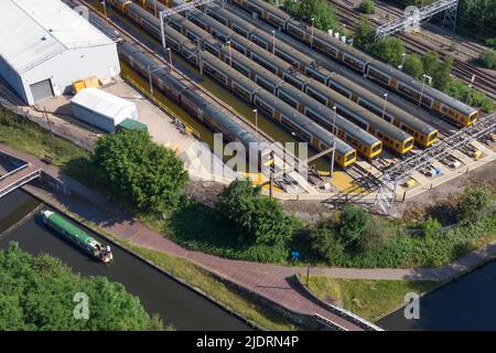 Birmingham, Inghilterra, 23 giugno 2022. Una barca sul canale passa i treni parcheggiati al deposito ferroviario Soho TMD a Smethwick. - La città delle Midlands di Birmingham è stata colpita da un'ora di punta molto affollata, mentre il secondo giorno di scioperi ferroviari ha colpito la Gran Bretagna giovedì 23 giugno. Le riprese aeree del centro della città mostravano ingorghi stradali che entravano in città, mentre i treni della West Midlands Railway erano inutilizzati al deposito ferroviario Soho TMD di Smethwick. Una barca sul canale che viaggiava a 4 km/h stava andando più veloce dei treni parcheggiati nelle vicinanze. L'Unione RMT sta spingendo per un aumento dei salari del 7% su tutti i fronti. PIC by: Stop premere Media / Alamy Live N Foto Stock