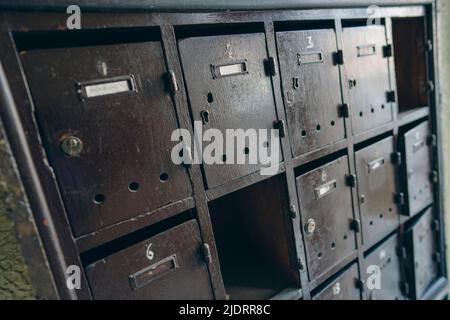 Molte cassette postali in legno in un vecchio edificio di appartamenti. Foto Stock