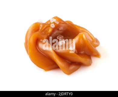 Roteare morbido al caramello con sale isolato su sfondo bianco. Salsa al caramello. Foto Stock