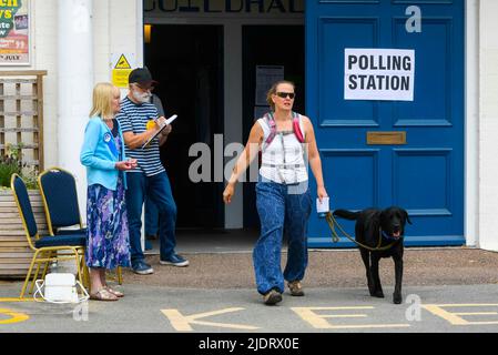 Axminster, Devon, Regno Unito. 23rd giugno 2022. Un elettore con un cane lascia il seggio alla Guild Hall di Axminster a Devon dopo aver votato per le elezioni parlamentari per la circoscrizione di Tiverton e Honiton. Picture Credit: Graham Hunt/Alamy Live News Foto Stock