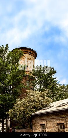 Vecchi edifici in mattoni a Telliskivi, Tallinn, Estonia. La struttura sullo sfondo è una torre ad acqua. Foto Stock