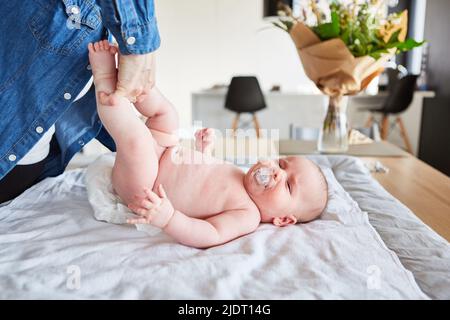 Pannolino da bambino con succhietto sul tavolo da cambiarsi a casa Foto Stock