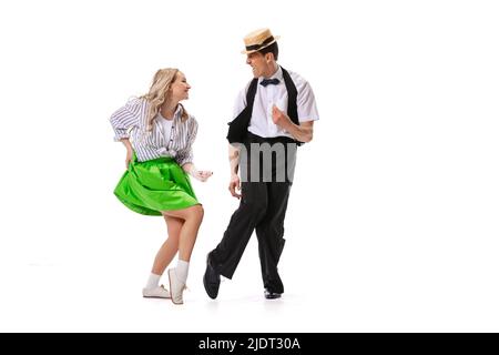 Stupito giovane uomo e donna in stile retrò abiti ballando lindy hop isolato su sfondo bianco. Arte, musica, moda, concetto di stile Foto Stock