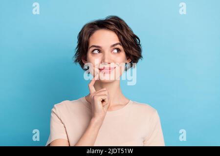 Ritratto di giovane donna interessata fantasizing guardare spazio vuoto brainstorming isolato su sfondo blu colore Foto Stock