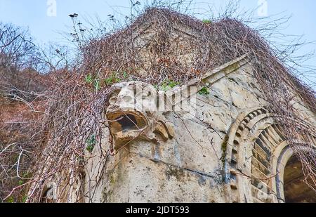 Scultura in gargoyle in pietra conservata all'angolo del vecchio padiglione in pietra intagliata della Cappella rupestre del Monastero Paolino, Budapest, Ungheria Foto Stock