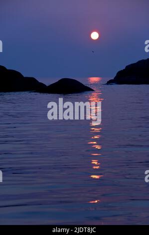 Il rosso sangue aprile set di sole nel mare ad ovest di Kirkehamn oin l isola di idratazione nel sud-ovest della Norvegia. Foto Stock