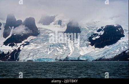 Ghiacciai e montagne foggose sul lato orientale del Prins Karl's Forland National Park, Svalbard, Norvegia. Foto da agosto 2019. Foto Stock