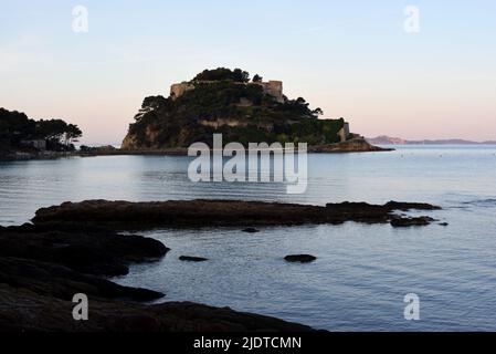 Sunrise o Dusk & Rocky Shoreline di fronte all'isola e Forte di Breganon Var Provence Francia Foto Stock