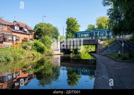 Tram che attraversa Nottingham e Beeston Canal in una giornata estiva soleggiata a Lenton, Nottinghamshire Inghilterra Regno Unito Foto Stock