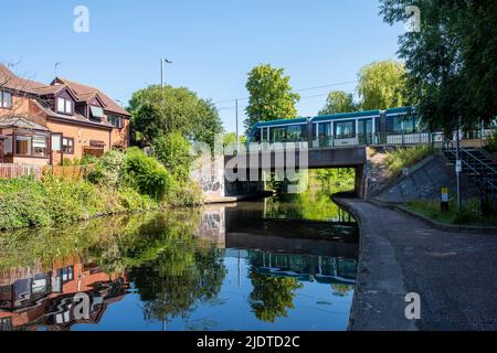 Tram che attraversa Nottingham e Beeston Canal in una giornata estiva soleggiata a Lenton, Nottinghamshire Inghilterra Regno Unito Foto Stock